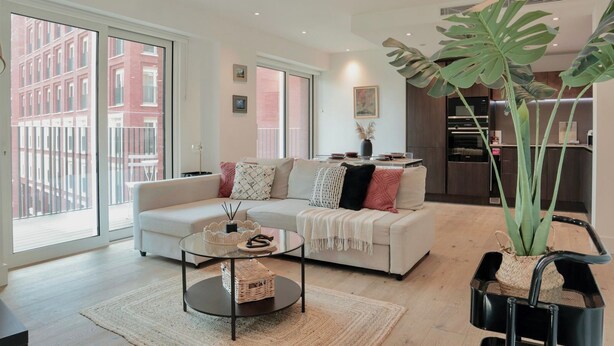 Un salon moderne avec un canapé, une table basse et de grandes fenêtres.