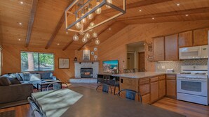 Une cuisine moderne avec des meubles en bois, un îlot central et un four à micro-ondes encastré.