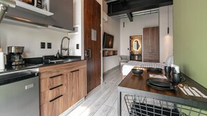 Une cuisine moderne avec des meubles en bois, un four encastré et une machine à café.