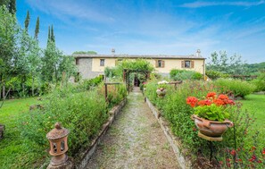 Stroll through the lush garden to the charming entrance of this traditional stone house.