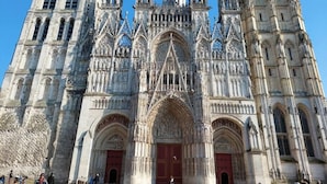 Una catedral gòtica amb treball de pedra intricat, grans portes arqueades i múltiples agulles.