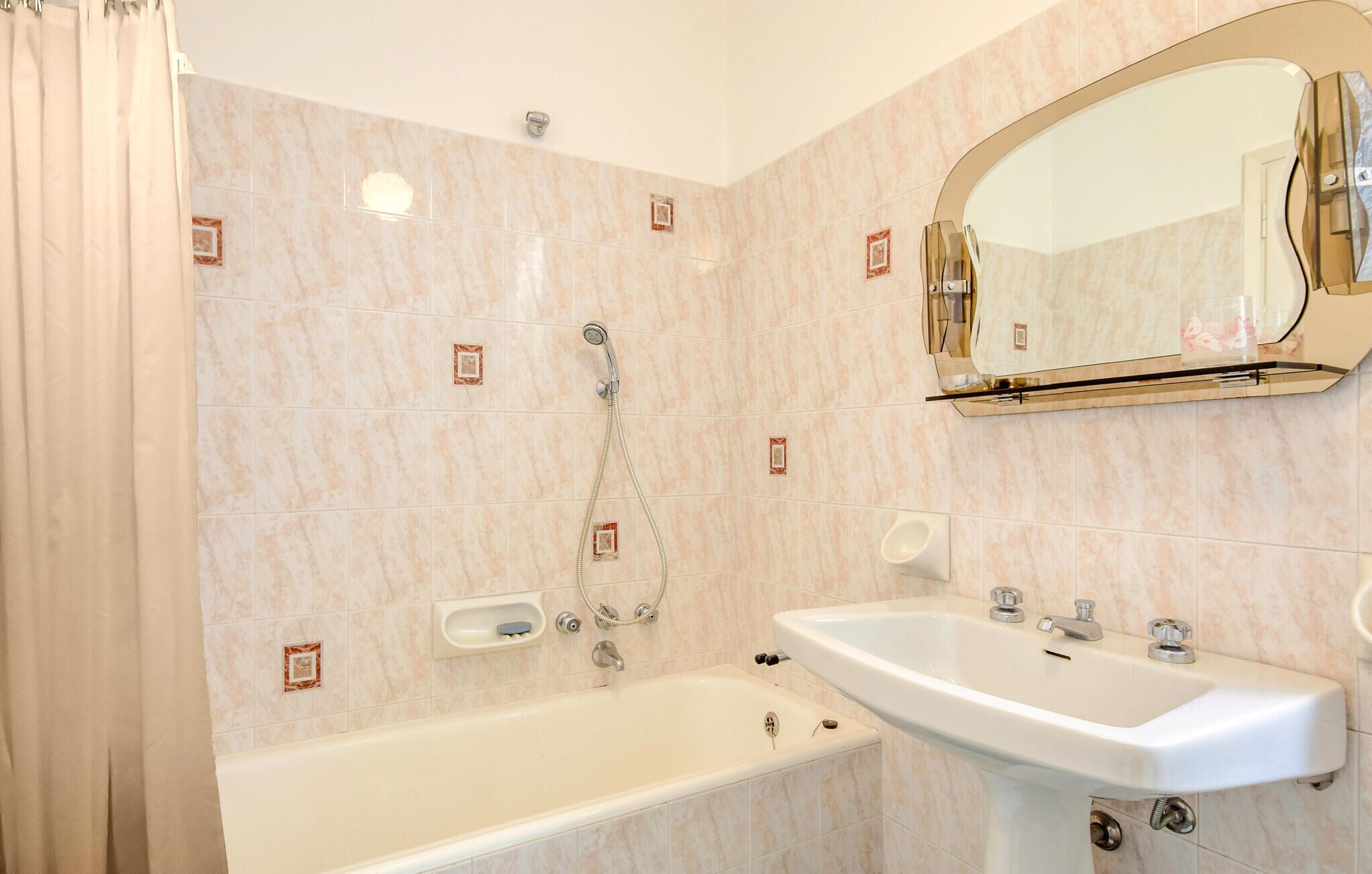 Ein Badezimmer mit einer Badewanne, einem Waschbecken und einem Spiegel.