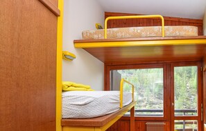 A bunk bed with a yellow railing, a window with a view of trees, and a wooden wall. - Gorgeous apartment in Breuil-Cervinia with WiFi (Breuil-Cervinia)