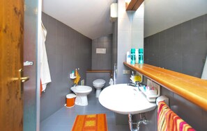 A modern bathroom with a wooden vanity, a white sink, two toilets, and a shower area. - Gorgeous apartment in Breuil-Cervinia with WiFi (Breuil-Cervinia)