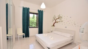 A bedroom with a bed, a chair, a window with curtains, a wall-mounted tree decal, and a bedside table. - 2 bedroom cozy home in Vasanello (Vasanello)