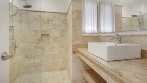 Ein Badezimmer mit Dusche, Waschbecken und Spiegel.