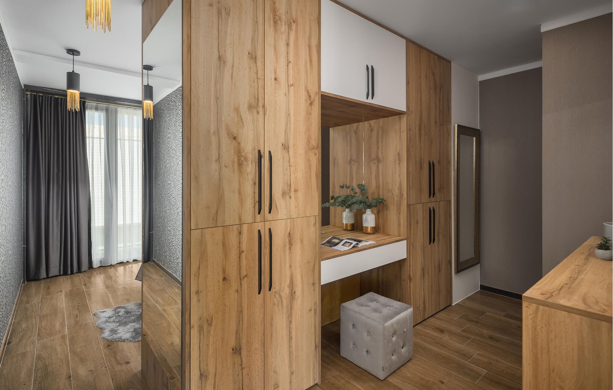 Una cocina moderna con armarios de madera, una encimera empotrada y un otomano gris tapizado.