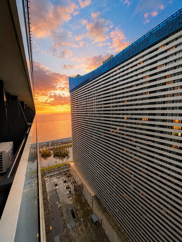 Un rascacielos con vista al atardecer sobre el agua.