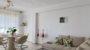 Un salon moderne comprenant un coin repas, un canapé, une table basse et une vue sur l’extérieur.