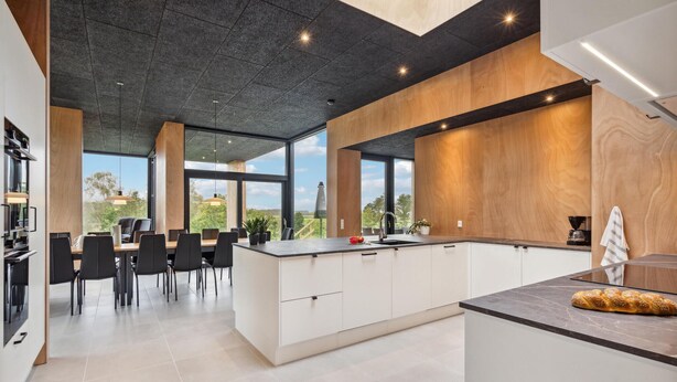 A modern kitchen with a large island, white cabinetry, and a view of the outdoors. - Lovely home in Højslev with sauna (Højslev)