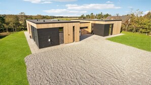 A modern, two-story building with a flat roof, large windows, and a gravel driveway. - Lovely home in Højslev with sauna (Højslev)