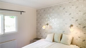 Makuuhuoneessa on sänky, kaksi yöpöytää, ikkuna ja patteri.
