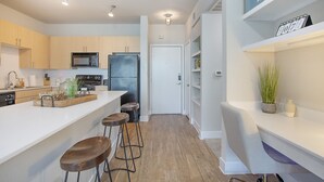 Een moderne keuken met een centraal kookeiland, barstoelen en inbouwapparatuur.