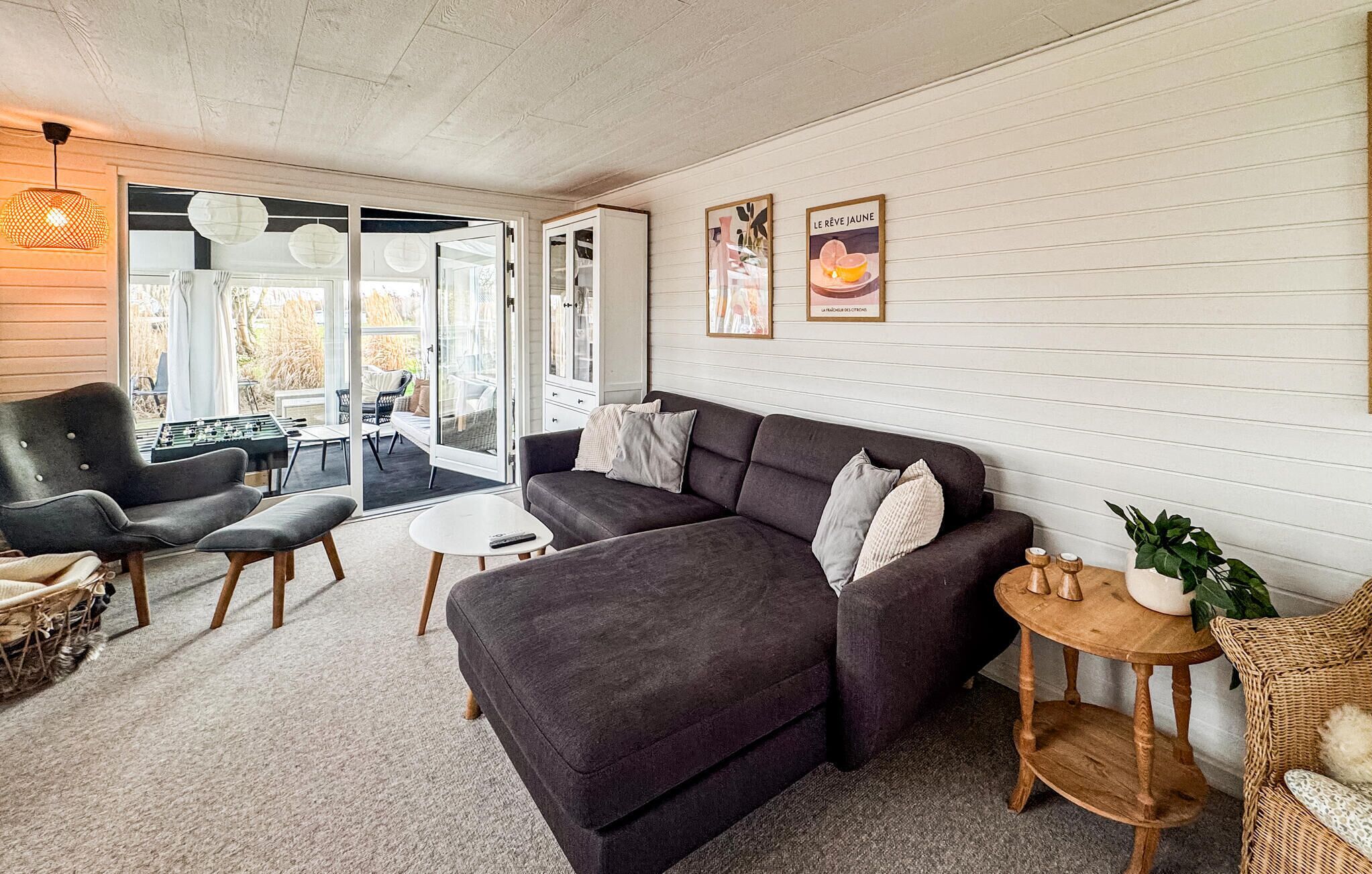 A cozy living room with a dark sofa, a small round table, and a wicker chair.