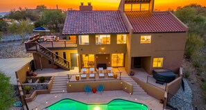 A two-story house with a swimming pool, outdoor seating, and a staircase leading to the upper level. - Desert Oasis: Heated Pool, Mini Golf, Hot Tub & Games (Tucson)