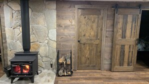 A stone wall, a wood-burning stove, and a rustic wooden door. - Minutes to town or very peaceful woods retreat! Close to trails and golf. (Lewiston)