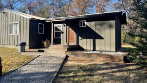 A two-story house with a front porch, a garage, and a small garden area. - Minutes to town or very peaceful woods retreat! Close to trails and golf. (Lewiston)