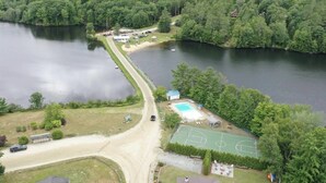 Une propriété située au bord d’un lac, dotée d’une piscine, d’un court de tennis et d’un petit chalet.