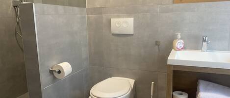 Un baño moderno con inodoro, bidé y lavamanos.