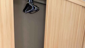 Een houten garderobe met meerdere planken en een kledingroede.