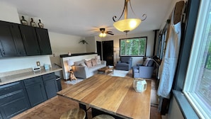 Una cocina moderna con una isla central, armarios oscuros y una zona de comedor con taburetes.