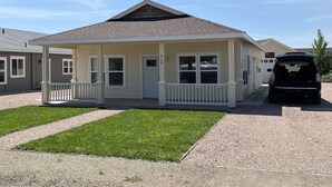 A single-story house with a front porch, a garage, and a driveway. - Beautiful Modern Lake House Along Lake Oahe. (Pierre)