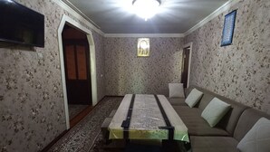 Une pièce avec un grand lit, un canapé, une moquette à motifs et un papier peint à fleurs.
