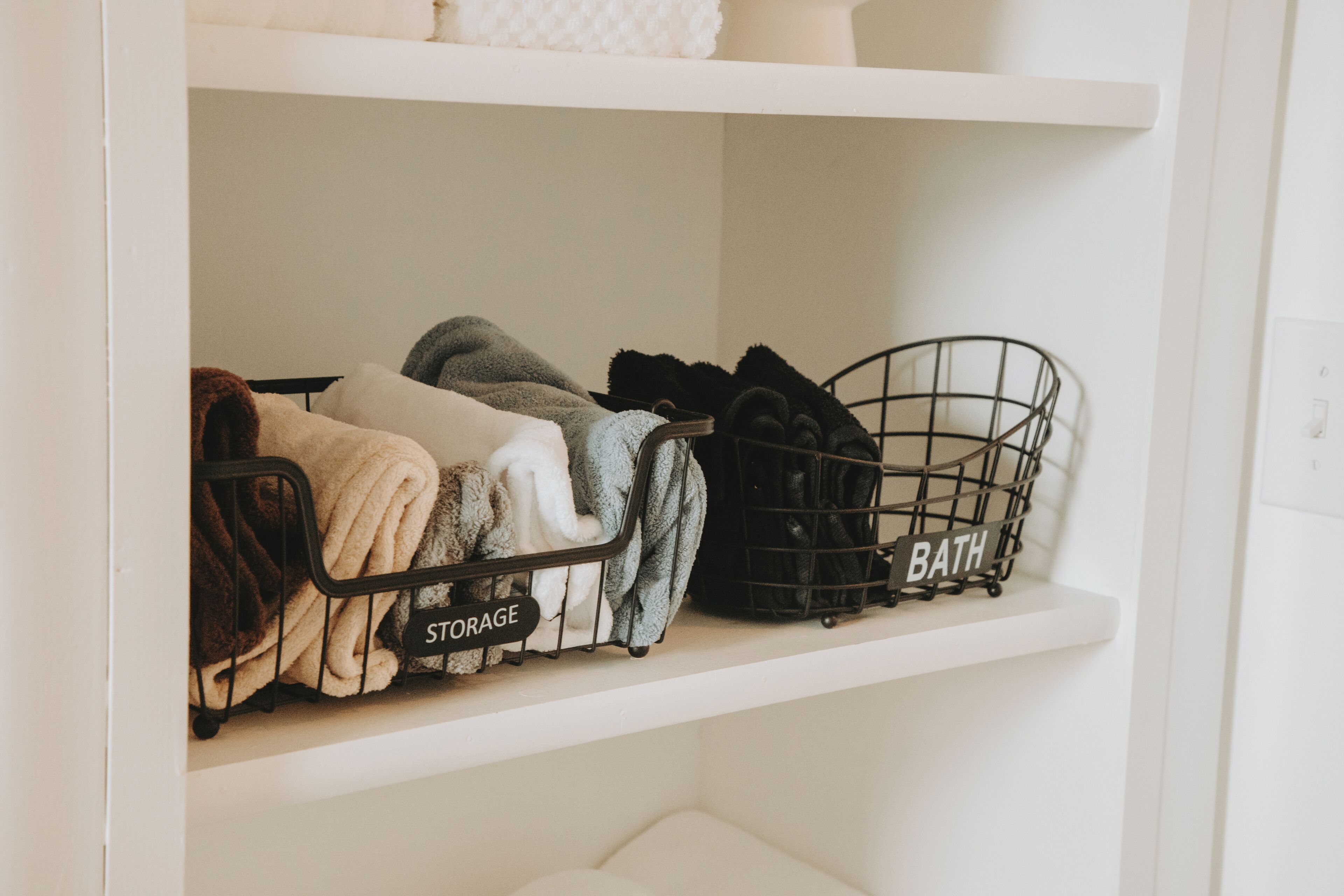 A storage shelf with labeled bins for 'STORAGE' and 'BATH'.