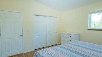 Ein Schlafzimmer mit einem Bett, einer Kommode und zwei Schränken.