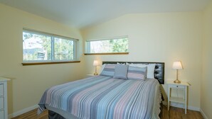 A bedroom with a large bed, two bedside tables, and two windows. - Modern Times (Big Bear Lake)