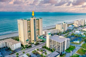 A high-rise hotel with a view of the ocean, parking facilities, and a parking garage. - Windy Hill Dunes-Oceanfront 3BD-Family Friendly (North Myrtle Beach)