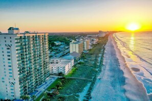 A high-rise hotel with multiple balconies, a beachfront view, and a parking area. - Windy Hill Dunes-Oceanfront 3BD-Family Friendly (North Myrtle Beach)