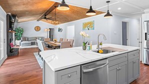 A modern kitchen with a large island, stainless steel appliances, and pendant lighting. - NEW IMMACULATE and quiet 4br Retreat between SAV DownTown & Tybee Island (Savannah)