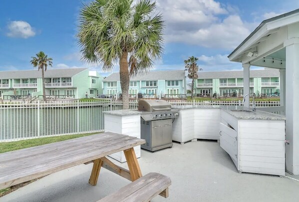 Guests can enjoy a barbecue on the patio, surrounded by hotel rooms and palm trees.