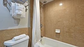 A bathroom with a bathtub, a toilet, and a shower.