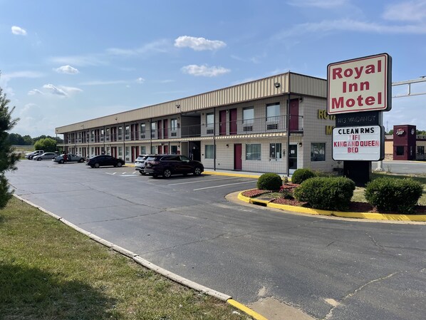 Un motel avec une enseigne publicitaire indiquant « Royal Inn Motel » et proposant des équipements tels que des « chambres propres », une connexion « Wi-Fi » et des « lits king-size et queen-size ».