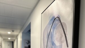 Ein Flur mit einem gerahmten abstrakten Gemälde an der Wand.