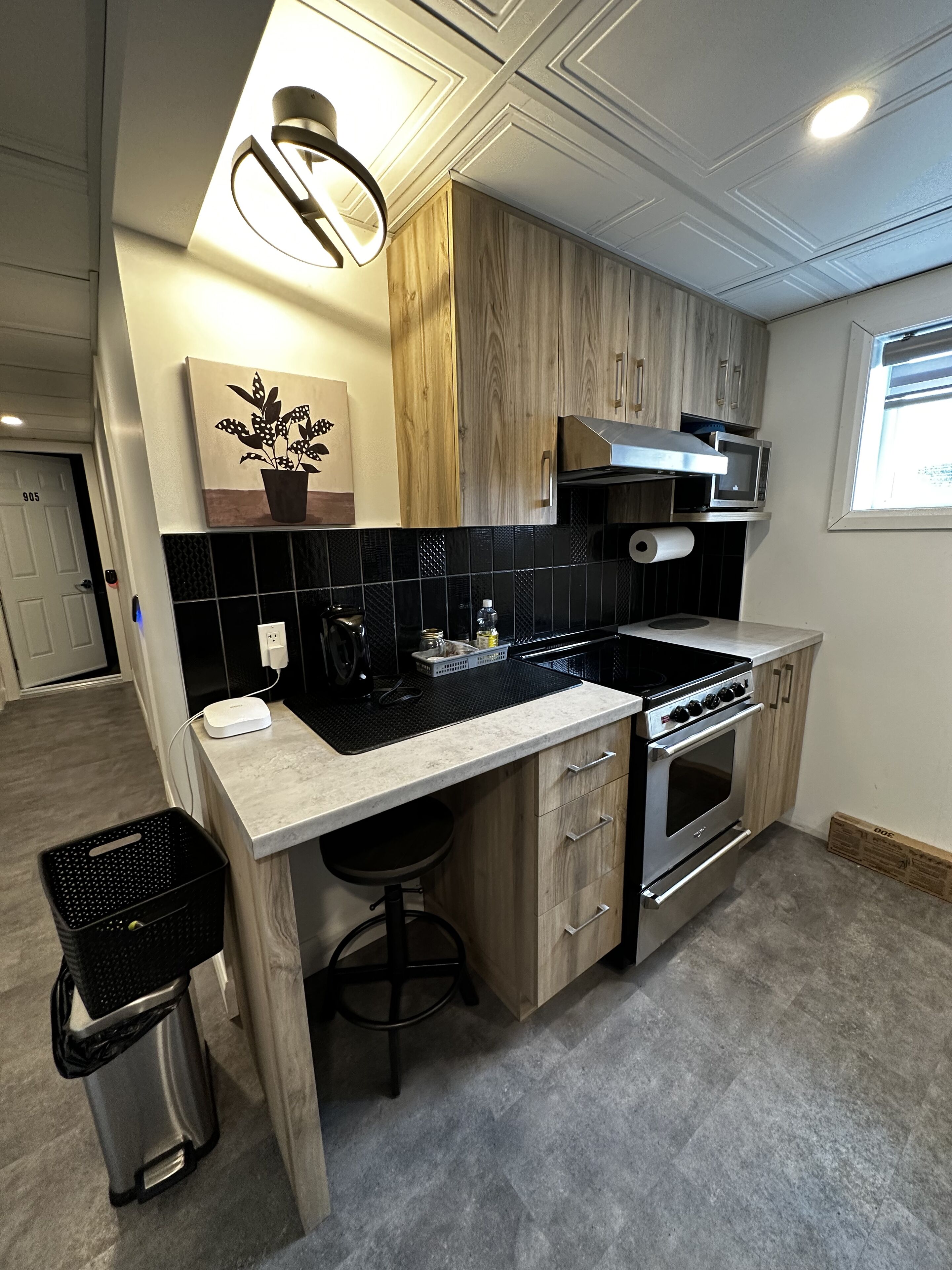 Une cuisine moderne dotée d’un îlot central, de meubles en bois, d’une cuisinière en acier inoxydable et d’un four à micro-ondes.