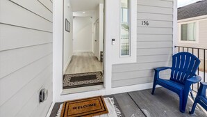 A house entrance with a door, a welcome mat, and a blue chair outside. - Beautiful home at Bear Lake sleeps 20+ with access to Ideal Beach included (Garden City)
