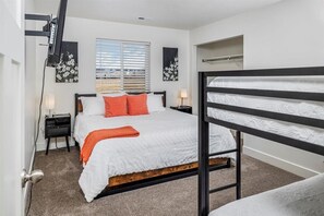A bedroom with a single bed, a TV mounted on the wall, and a window with blinds. - Beautiful home at Bear Lake sleeps 20+ with access to Ideal Beach included (Garden City)