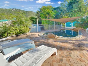 A pool area with lounge chairs, a pool, and a view of a mountain. - Magnetic Reef Unit 2 (Arcadia)
