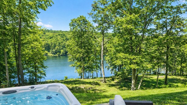 Un jacuzzi con vistas a un lago rodeado de árboles.
