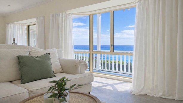 A spacious living room with a large window offering a view of the ocean. - Ocean View Holiday Home near Beach in Mount Martha (Mount Martha)