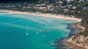An aerial view of a coastal area with a beach, boats, and residential buildings. - Ocean View Holiday Home near Beach in Mount Martha (Mount Martha)