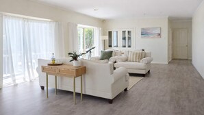 A spacious living room with a sofa set, a coffee table, and a painting on the wall. - Ocean View Holiday Home near Beach in Mount Martha (Mount Martha)
