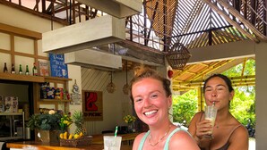 Un espace bar avec des meubles en bois et une enseigne sur laquelle on peut lire : « Buvez du café, de la bière et profitez de la vie. »