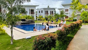 Un espace piscine offrant une vue dégagée sur la piscine, des chaises longues et la végétation environnante.