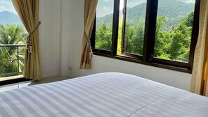 A bedroom with a large bed, a balcony, and a view of a green landscape through the window. - Penthouse Seaview Apartment - 3 Bedroom, Sleeps up to 8 (Tambon Ko Tao)