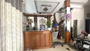 A kitchen with a wooden counter, a staircase, and a motorcycle parked outside. - SPOT ON 1188 Motel Hoa Cam (Da Nang)