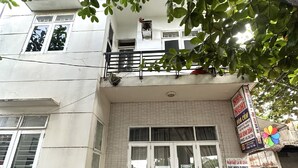 A building with a tiled facade, a gated entrance, and potted plants at the entrance. - SPOT ON 1188 Motel Hoa Cam (Da Nang)